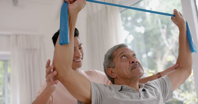 Young Caregiver Assisting Senior with Stretching Exercise at Home - Download Free Stock Images Pikwizard.com