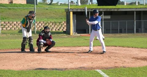 Baseball game action with players ready at home plate