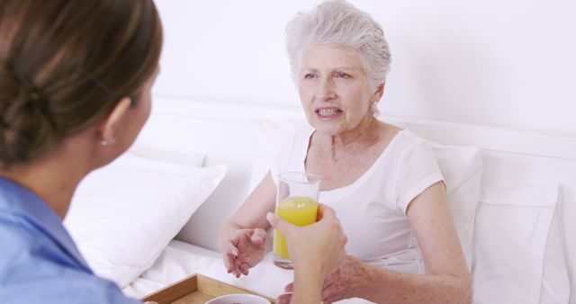 Nurse Assisting Elderly Woman in Bed with Glass of Juice - Download Free Stock Images Pikwizard.com