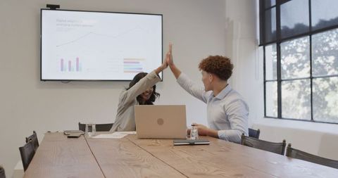 Diverse colleagues celebrate a successful meeting with high five