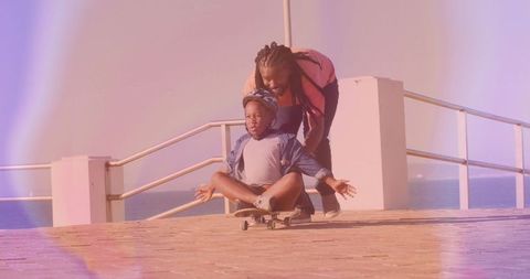 Father guiding son on skateboard in coastal adventure