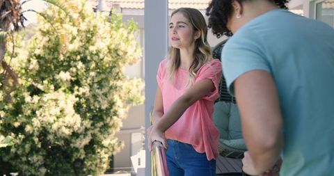 Young couple cherishing moment with engagement ring on sunny patio