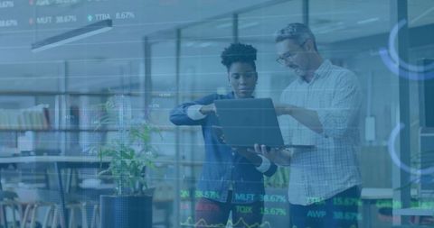 Colleagues Analyzing Stock Market Using Laptop in Modern Office Workspace