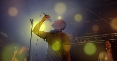 Dynamic lead singer performing on stage in vibrant lighting