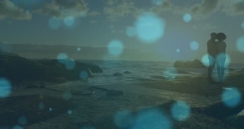 Mystical View of Couple on Seaside Rocks at Sunset