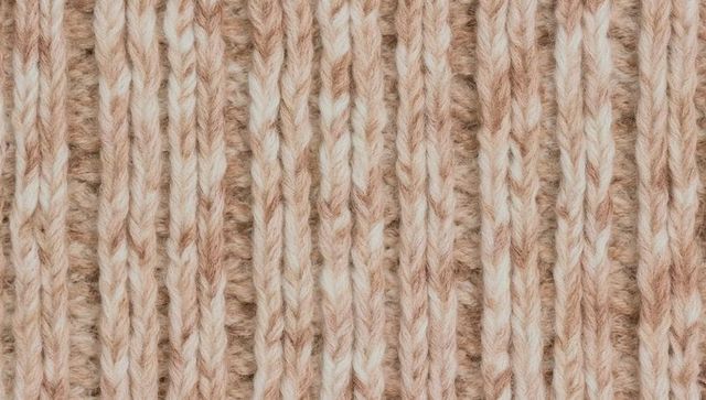 Displaying two-tone ribbed wool knit texture close-up, soft variegated yarn pattern