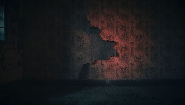 Peeling floral wallpaper in a distressed antique room interior