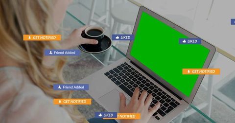 Woman typing on laptop with green screen and social media notifications for mockups