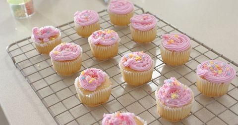 Vanilla Cupcakes Cooling on Wire Rack with Pink Buttercream and Sprinkles