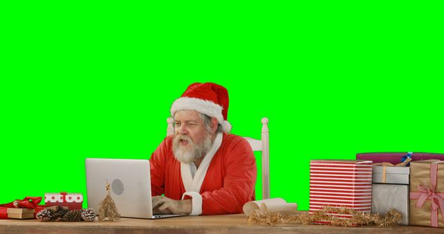 Santa Claus Using Laptop Surrounded by Christmas Gifts and Decorations - Download Free Stock Images Pikwizard.com