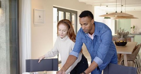 Couple Setting Dinner Table in Bright Modern Kitchen