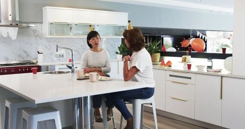 Senior Friends Enjoying Conversation in Modern Kitchen