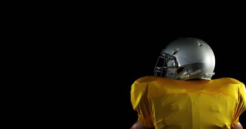 American football player mid-throw isolated on black background
