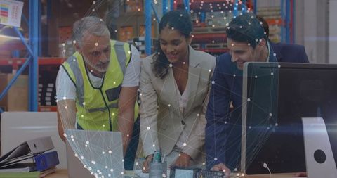 Diverse business team collaborating in modern warehouse environment