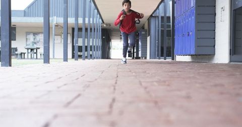 Boy Running in School Corridor with Backpack - Download Free Stock Images Pikwizard.com