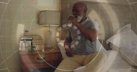 Mature man drinking water on bed with medication and bedside lamp, calm morning routine