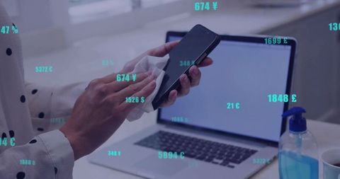 Woman sanitizing smartphone in modern home office workspace for cleanliness