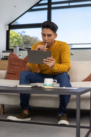Man using tablet with stylus in modern home setting