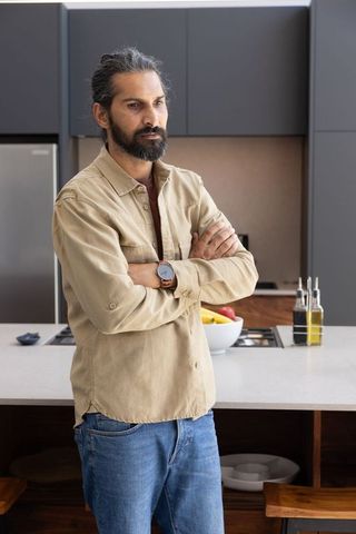 Contemplative Middle-Aged Man Standing in Modern Kitchen