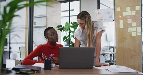 Two Women Collaborating in Modern Office, Discussing Business Strategies
