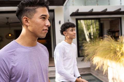 Hispanic Male Friends Standing by Modern Patio Reflecting Pool