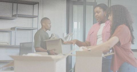 Office move team packing boxes and organizing supplies with bubble wrap and shelving