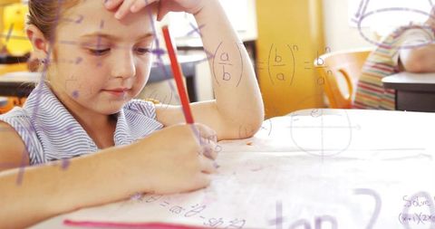 Young student concentrating on math worksheet with red pencil and handwritten equations