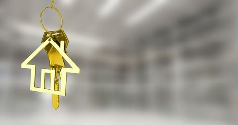 Golden House Key on Blurred Interior Background