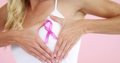Woman Promoting Breast Cancer Awareness with Pink Ribbon on Chest
