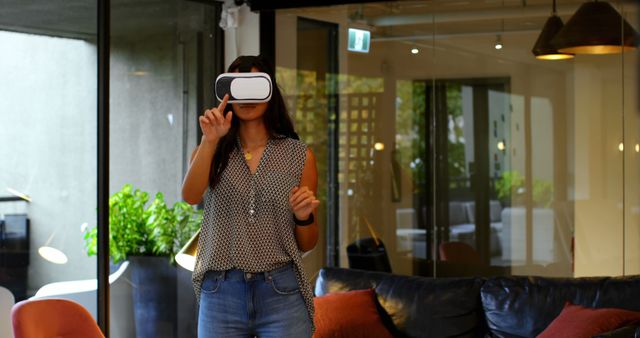 Woman Experiencing Virtual Reality with VR Headset in Modern Living Room - Download Free Stock Images Pikwizard.com