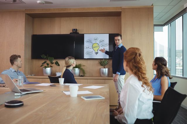 Businessman Presenting Strategy to Colleagues in Modern Boardroom - Download Free Stock Photos Pikwizard.com