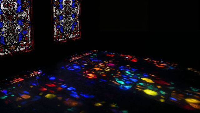Colorful shadows cast on stone floor in historic cathedral