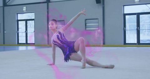 Teenage rhythmic gymnastics dancer posing on floor in ice rink with purple leotard