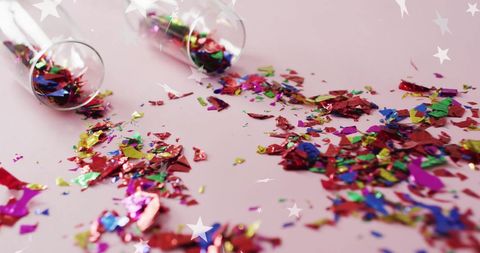 Vibrant Confetti Scattered from Glass on Pink Background