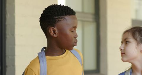 Diverse students school entrance backpacks black boy and asian girl facing each other