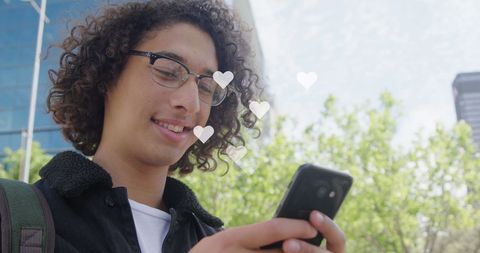 Smiling Young Adult Engaging with Smartphone Outdoors