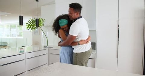 Loving Couple Embraces Joyfully in Modern Kitchen