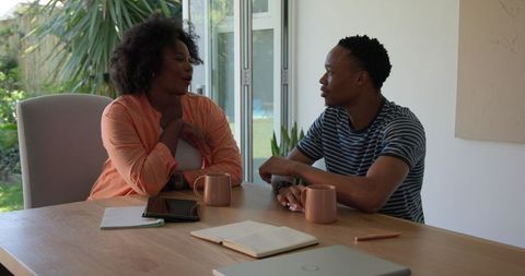 Young Couple Enjoying Coffee and Conversation in Home Setting