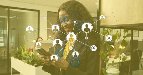 Businesswoman Using Smartphone Analyzing Network in Open Office