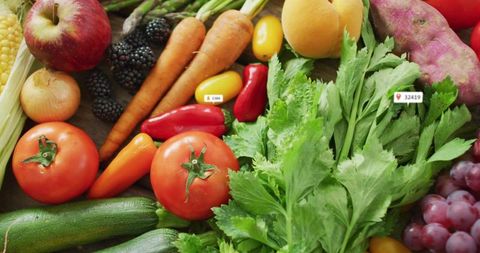 Vibrant flat-lay showing fresh fruits and vegetables with market labels on wooden countertop