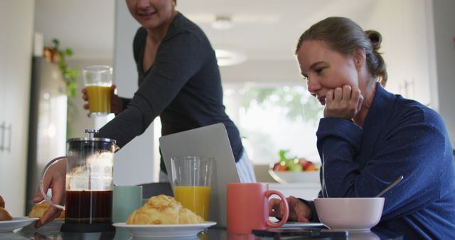 Caucasian lesbian couple having a imagecall on laptop while having breakfast at home - Download Free Stock Photos Pikwizard.com