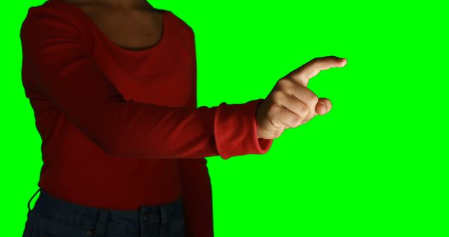 Person wearing red shirt pointing with index finger against green screen background, useful for illustrating gestures, touchscreen interfaces, technology interaction, or body language. Ideal for use in presentations, educational materials, advertisements, or apps requiring human interaction imagery.
