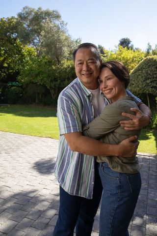 Happy Diverse Couple Embracing Outdoors Under Sunlight