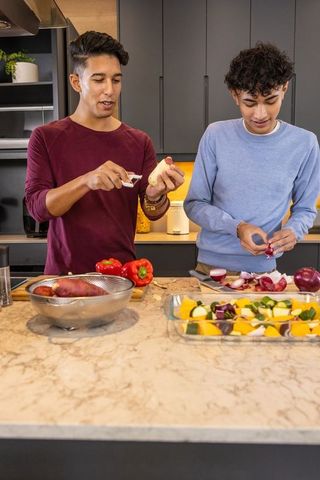 Male Friends Joyful Cooking Together Chopping Vegetables