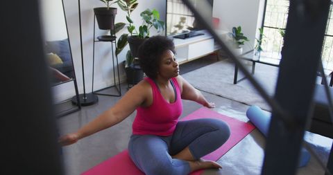 Woman practicing yoga on mat at home during pandemic isolation