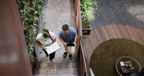 Colleagues Walking and Discussing Project in Eco-Friendly Office