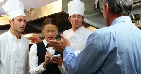 Restaurant Staff Receiving Instructions in Busy Kitchen