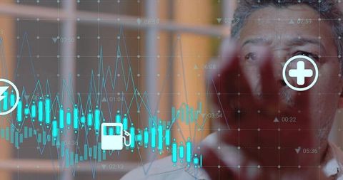 Mature man analyzing holographic financial charts and icons on futuristic office display