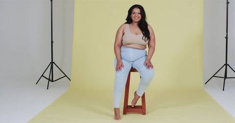 Confident Plus-Size Woman Posing Against Yellow Studio Backdrop