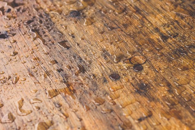 This image features water droplets scattered over a wooden surface, showcasing texture and moisture. It is ideal for backgrounds, design projects, and advertisements related to natural elements, moisture, construction, or the environment. This image can be used in presentations, brochures, websites, and articles focusing on environmental themes or interior design that emphasizes natural materials.